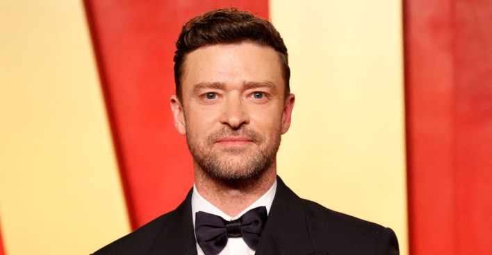 Justin Timberlake im Anzug mit Fliege vor gelb-rot-gestreiftem Hintergrund