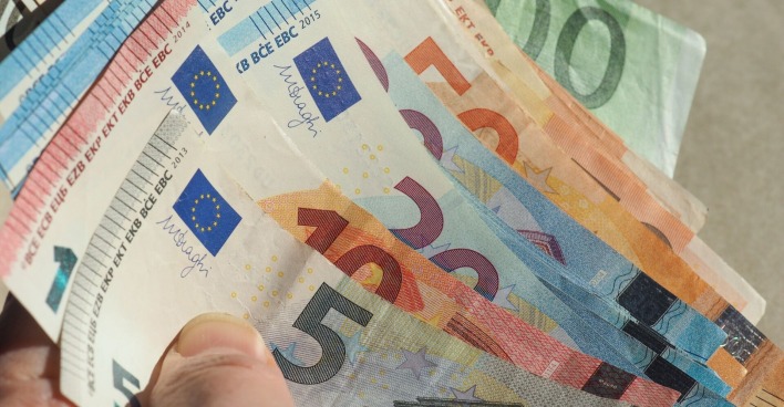 Hand hält aufgefächerte Euro-Banknoten in verschiedenen Stückelungen (5, 10, 20, 50, 100 Euro).