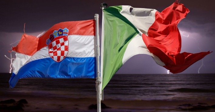 Zwei wehende Flaggen von Kroatien und Italien vor düsterem Himmel mit Blitzen über dem Meer – Symbol für die aktuellen Unwetter an der Adria.