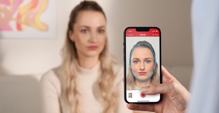 Junge Frau wird mit Handy fotografiert