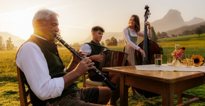 Drei Musikanten spielen auf einer Alm.