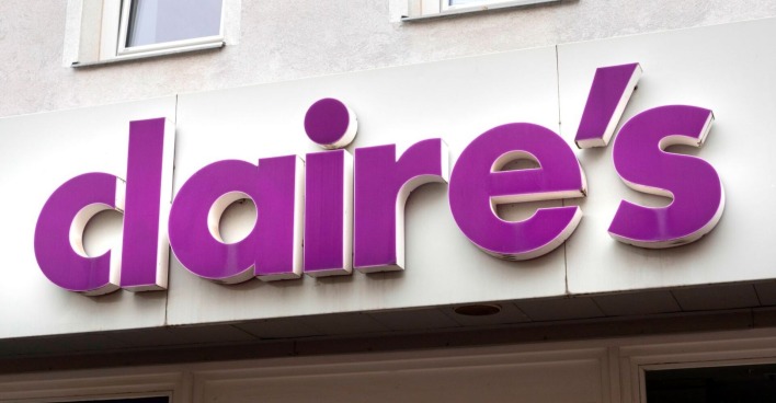 Violett-weißes Claire’s-Firmenschild an der Fassade eines Geschäftsgebäudes, Nahaufnahme der Ladenaufschrift.