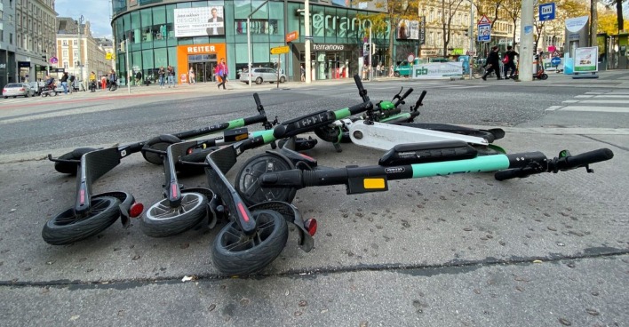 E-Roller verschiedener Leihdienste liegen auf der Wiener Mariahilfer Straße