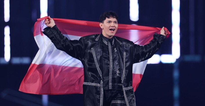 ESC-Sieger JJ hält die österreichische Flagge hinter sich und jubelt auf der Bühne beim Eurovision Song Contest 2025.
