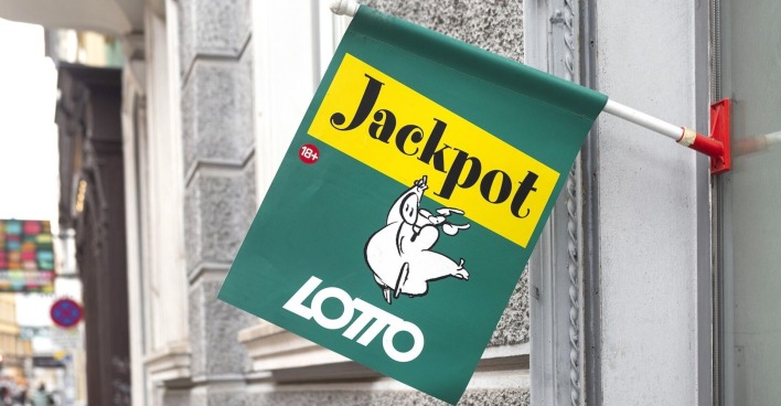 Grune Lotto-Fahne vor einer Trafik mit dem Lotto-Schwein als Markenzeichen