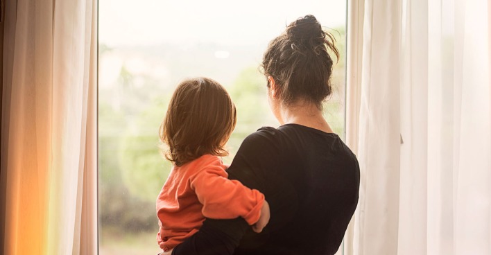 Frau mit Kind am Fenster | Credit: iStock.com/Kaan Sezer
