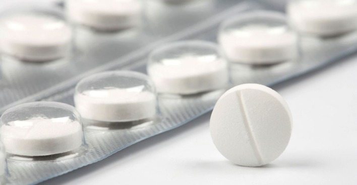 Nahaufnahme einer weißen Tablette vor einer Blisterverpackung mit weiteren Tabletten – symbolisch für das Schmerzmittel Paracetamol.