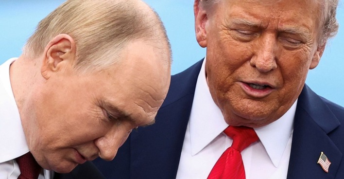 Wladimir Putin und Donald Trump stehen eng beieinander und wirken konzentriert im Gespräch. Putins Kopf ist leicht geneigt, Trump hat die Augen geschlossen und spricht.