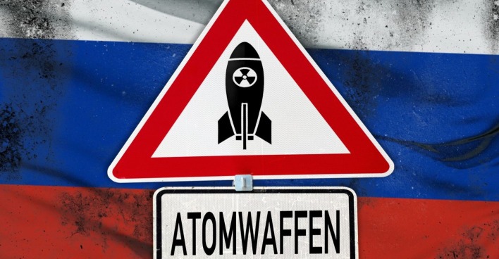 Atomwaffen, Schriftzug auf einem Warnschild mit Atombombe. Symbolbild globale Bedrohung: