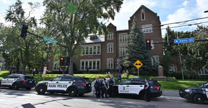 Mehrere Polizeiautos und Beamte stehen vor der Annunciation Catholic School in Minneapolis an der Kreuzung Garfield Avenue und West 54th Street nach einer Schießerei während einer Messe.