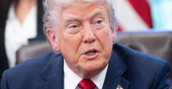 Donald Trump spricht bei einem Treffen im Weißen Haus. Der US-Präsident blickt ernst und trägt einen dunkelblauen Anzug mit roter Krawatte.