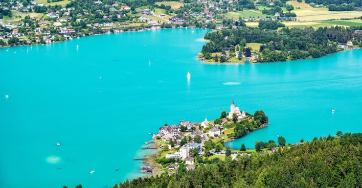 Luftaufnahme von Maria Wörth am Wörthersee mit türkisblauem Wasser, Segelbooten und Uferbebauung, Schauplatz des aktuellen Suchdramas.