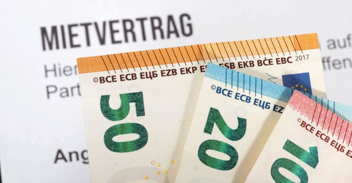 Nahaufnahme von 50-, 20- und 10-Euro-Scheinen, die vor einem Mietvertrag liegen – Symbolbild zum Thema Mietkosten und Vertragsbedingungen.
