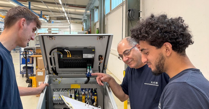 Ausbildner in der Werkshalle mit Lehrlingen im Gespräch | Credit: Lea Automatisierungstechnik