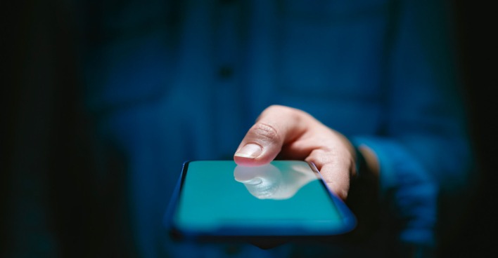 Symbolbild Smartphone in der Hand einer nicht erkennbaren Person