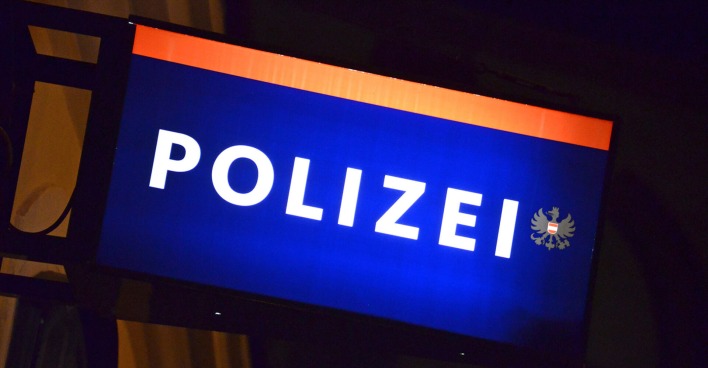 Symbolbild: Beleuchtetes Schild einer Polizeiinspektion