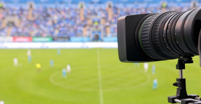 Fernsehkamera in einem Fußballstadion, welche auf das Spielfeld zeigt