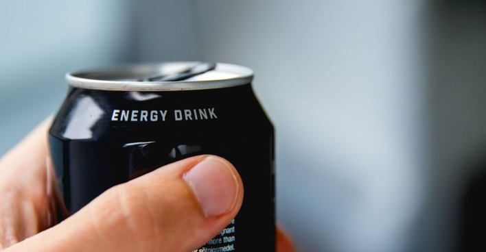 Nahaufnahme einer menschlichen Hand, die eine Dose Energydrink hält