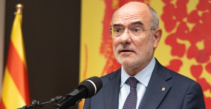 Regionalminister Jaume Duch mit Mikrophon am Podium
