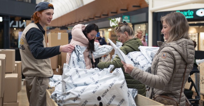 Drei Frauen suchen am Wühltisch nach Überraschungspaketen