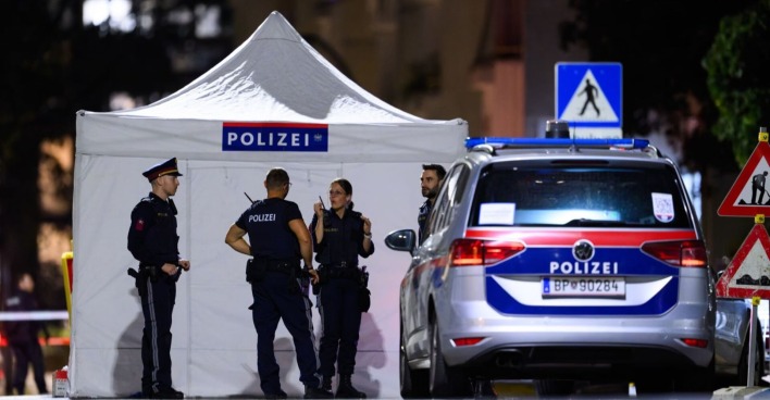 Polizisten vor einem weißen Sichtschutzzelt und einem Polizeiwagen am Tatort in Wien-Leopoldstadt nach der tödlichen Schießerei.