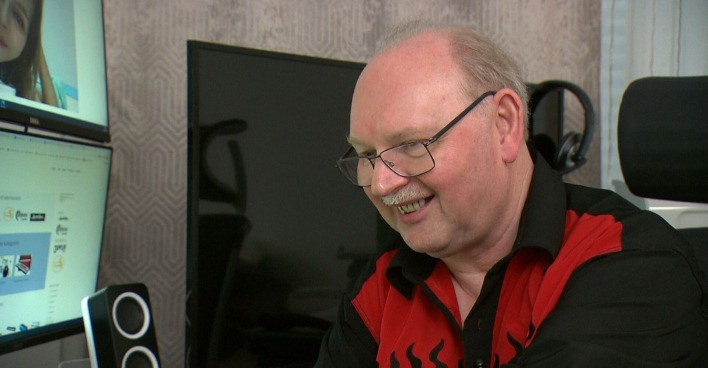 Charly aus dem Format Amore unter Palmen in seiner Wohnung vor einem Computer sitzend