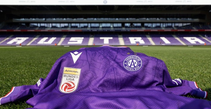 Trikot des FK Austria Wien auf dem Rasen der Generali Arena liegend, im Hintergrund eine Tribüne mit Austria-Schriftzug