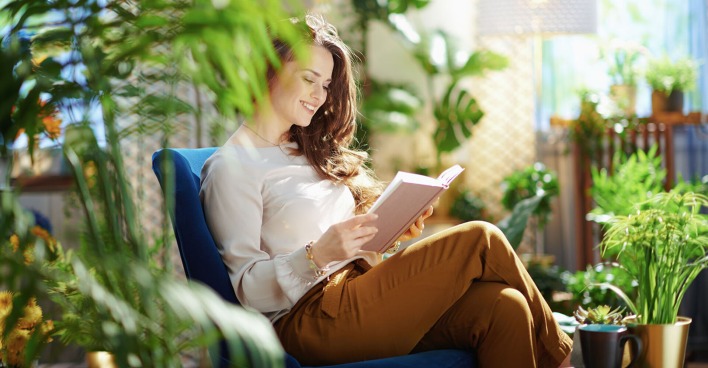 Frau sitzt in der Mitte von Pflanzen | Credit: iStock.com/CentralITAlliance