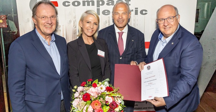 Gratulanten mit Blumen und Urkunde