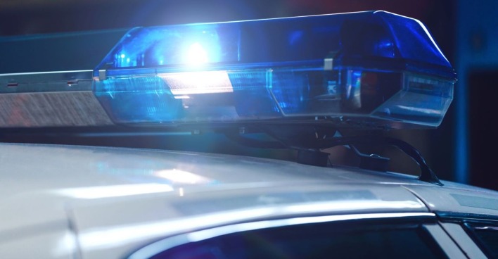 Polizeiwagen in der Nacht mit eingeschalteter Sirene auf dem Fahrzeugdach