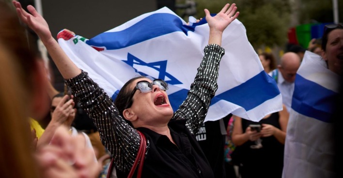 Frau jubelt mit israelischer Flagge in Tel Aviv nach der Einigung zwischen Israel und der Hamas auf eine Waffenruhe und einen Gefangenenaustausch.