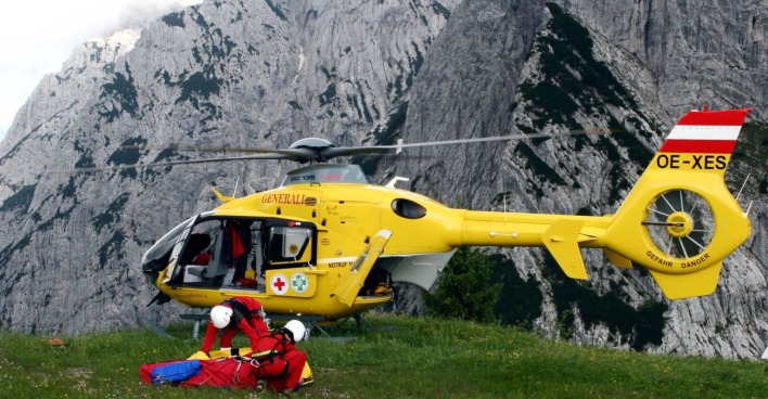 Rettungskräfte mit ÖAMTC-Hubschrauber bei einem Einsatz in den Bergen.