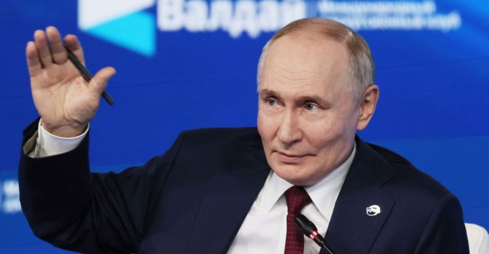 Wladimir Putin hebt während einer Podiumsdiskussion beim Waldai-Forum in Sotschi die Hand und lächelt, während er über Drohnensichtungen in Europa spricht.