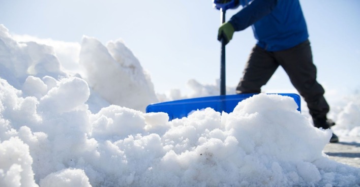 Schwere Schneeräumung mit einem Schneedumper an einem sonnigen Tag