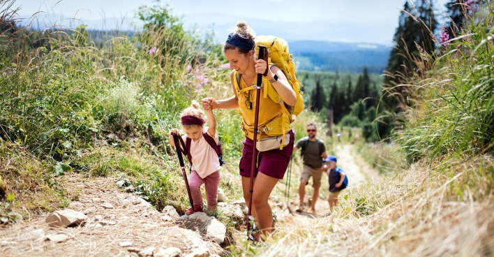 Junges Elternpaar beim Wandern mit seinen Kindern | Credit: iStock.com/Halfpoint