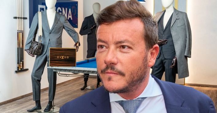 René Benko vor Designeranzügen und Accessoires, die im Zuge seiner Insolvenz versteigert werden – darunter ein Louis-Vuitton-Humidor und edle Maßanzüge.