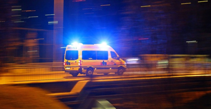 Rettungsauto mit Blaulicht auf einer Brücke