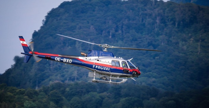 Polizeihubschrauber Libelle vor einer Berglandschaft - Symbolbild für den bei einem Skiunfall in Nassfeld tödlich verunglückten Lehrer.