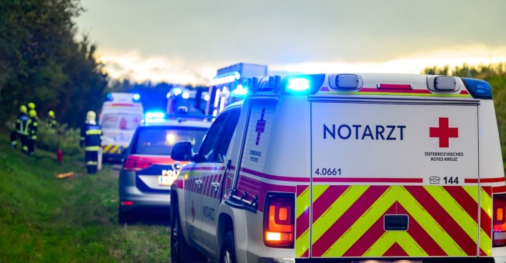 Rettungs- und Polizeiwagen an einer Unfallstelle mit eingeschalteter Sirene