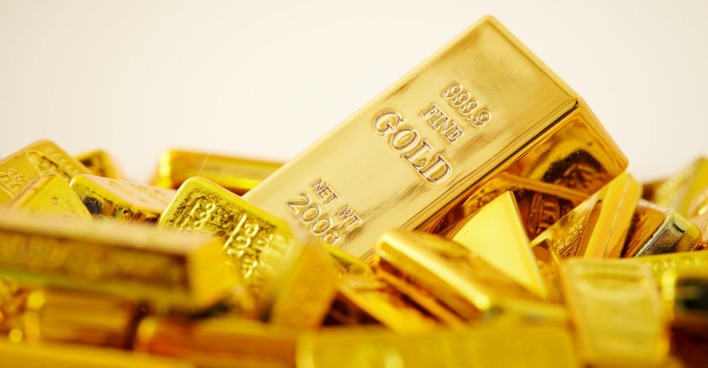 Eine große Anzahl Goldbarren liegt vor einem hellen Hinergrund
