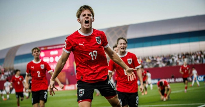 Johannes Moser im roten Trikot jubelt lautstark über ein Tor, im Hintergrund feiern seine Teamkollegen während des Halbfinales gegen Italien.