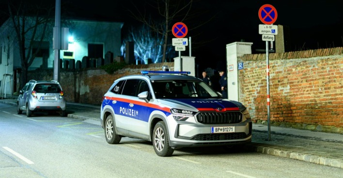 Eingangsbereich des Friedhofs Baumgarten in Wien mit Wagen der Polizei nach einem Gewaltverbrechen.