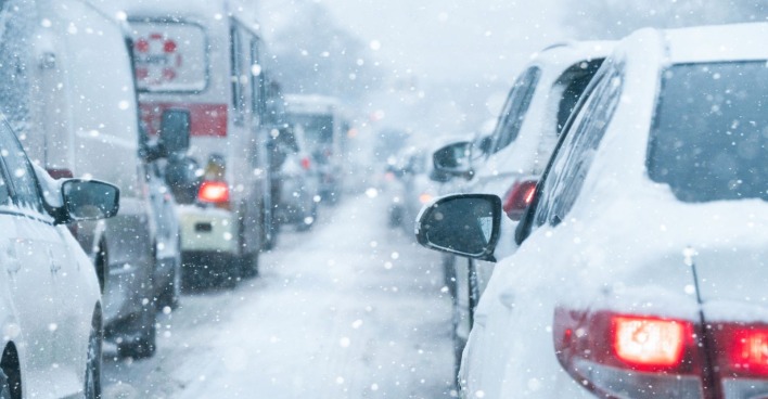 Autos stehen bei starkem Schneefall im Stau während eines Blizzard in New York, Straßen wegen Schneesturm und Ausnahmezustand gesperrt
