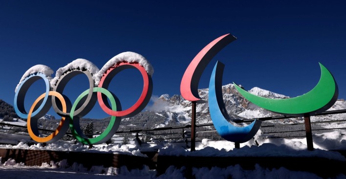Olympische Ringe und Paralympics-Symbol stehen verschneit vor einer winterlichen Bergkulisse unter blauem Himmel/ Olympiasieger Michael Rösch spricht über Suizidgedanken und Depressionen