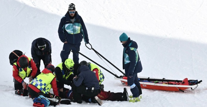 Mehrere Sanitäter und Helfer leisten auf der Schneepiste Erste Hilfe für Liu Jiayu nach ihrem Sturz in der Halfpipe bei den Olympischen Winterspielen 2026; im Hintergrund steht ein Rettungsschlitten bereit.