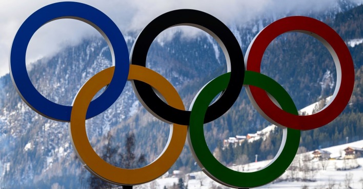 Olympische Ringe vor verschneiten Bergen in Cortina d’Ampezzo, Symbol der Olympischen Winterspiele 2026.