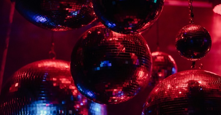 Viele Discokugeln hängen an der Decke.