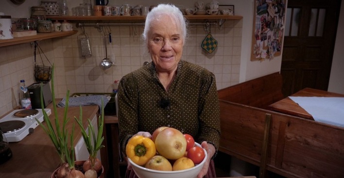 Ursula Erber in einer Küchenszene aus „Dahoam is Dahoam“, sie hält eine Schüssel mit Obst in den Händen/Ursula Erber Ausstieg "Dahoam is Dahoam"