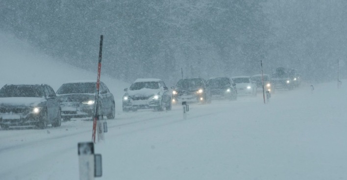 Das Wetter sorgt für anhaltende ProblemeAutos stauen sich auf einer schneebedeckten Straße in Österreich während starken Schneefalls.