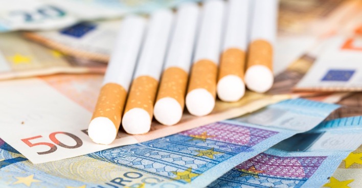 Mehrere Zigaretten liegen auf Euro-Banknoten und symbolisieren die steigenden Tabakpreise in Österreich im März 2026.